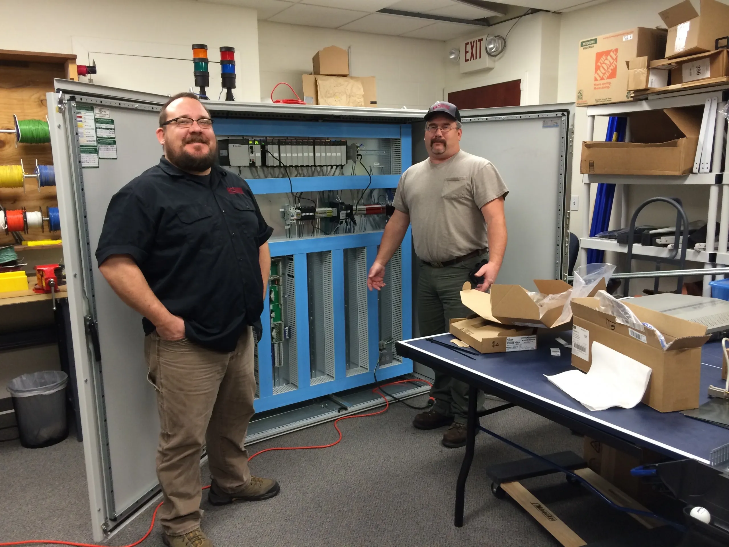 Advanced Control Systems team member in the panel shop working on a control panel for a SCADA system